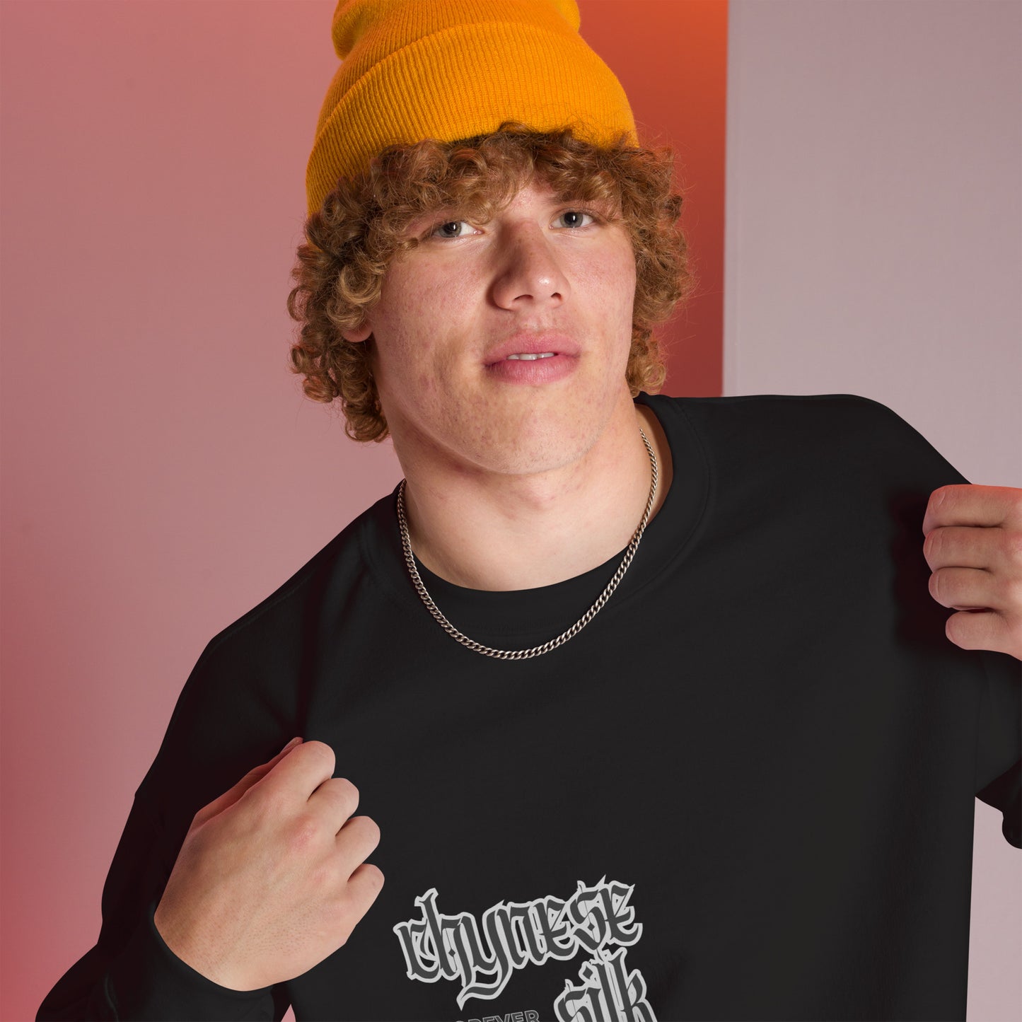 Male model wearing an orange beanie and a black premium Chynese Silk Gothic Revival streetwear sweatshirt with black typography.